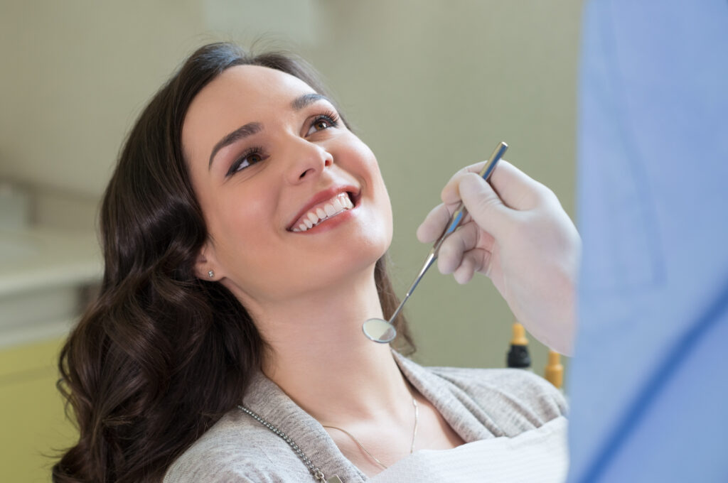 Closeup of dentist examining young woman's teeth