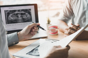 Asian young dentists are explaining about the dental root treatment of patients in the office.